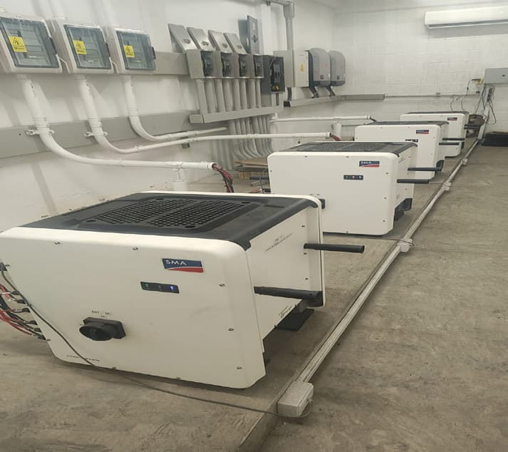 Banco de cinco inversores SMA instalados en el cuarto eléctrico de una nave industrial, con canalización y tableros de protección.