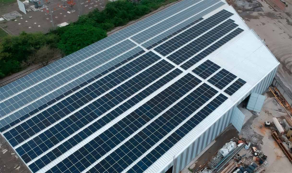 Vista aérea de una nave industrial con la cubierta completamente ocupada por paneles solares instalados por Swivel Energy.